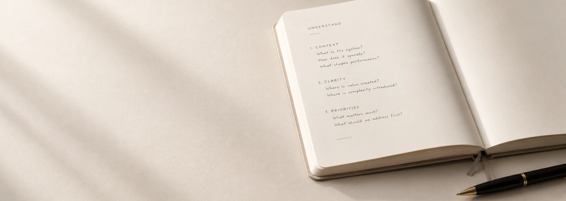 open notebook iwth structured assessment headings and pen resting alongside